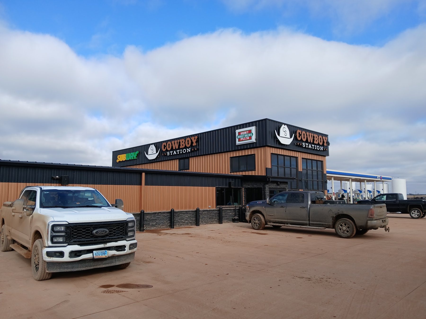 Pickups and trucks parked along the front of Cowboy Station.