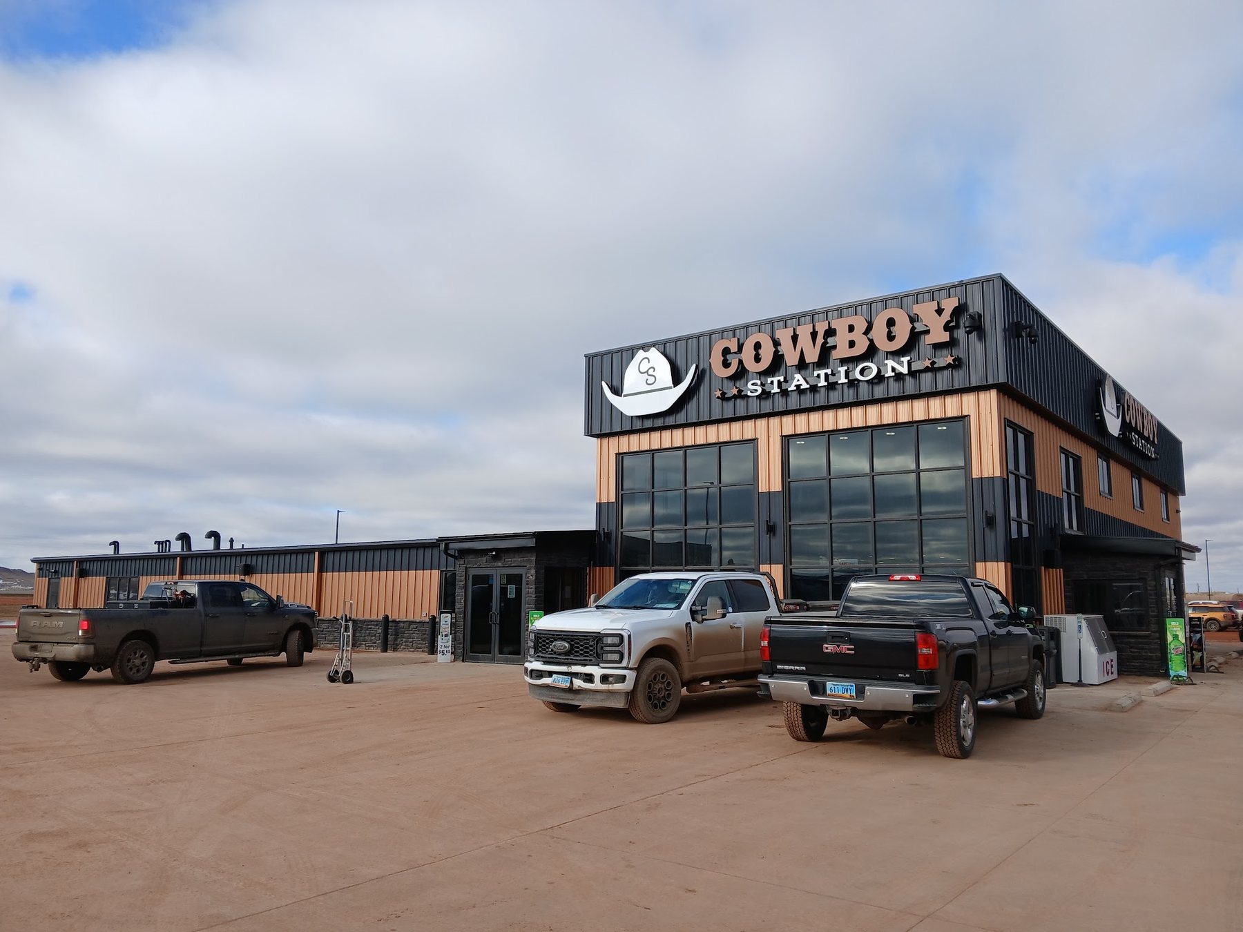 Pickups parked outside the Cowboy Station store on a clear day.