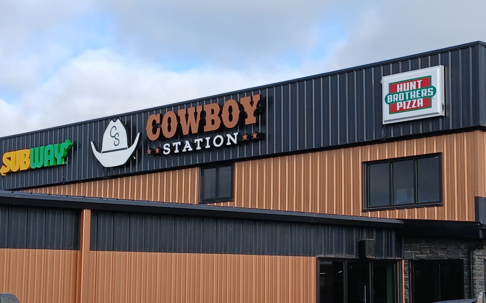 Subway, Cowboy Station and Hunt Brothers Pizza signs along the top of the building.